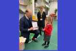 Leo Docherty MP at North Farnborough Infant School, presenting the winning design to Alice Childs, winner of the Schools Christmas Card Competition 2023