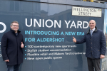Leo and Cllr Gareth Lyon standing in front of the Union Yard sign, which surrounds the scaffolding